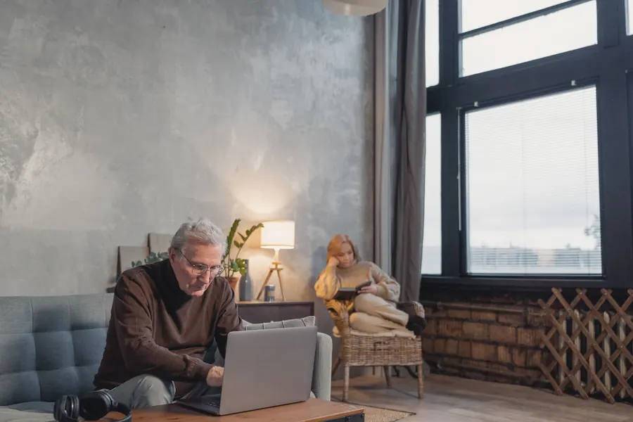 Older man working on a laptop in his living room