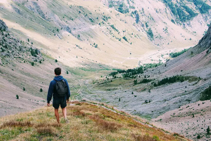 Man hiking alone through a wide mountain valley