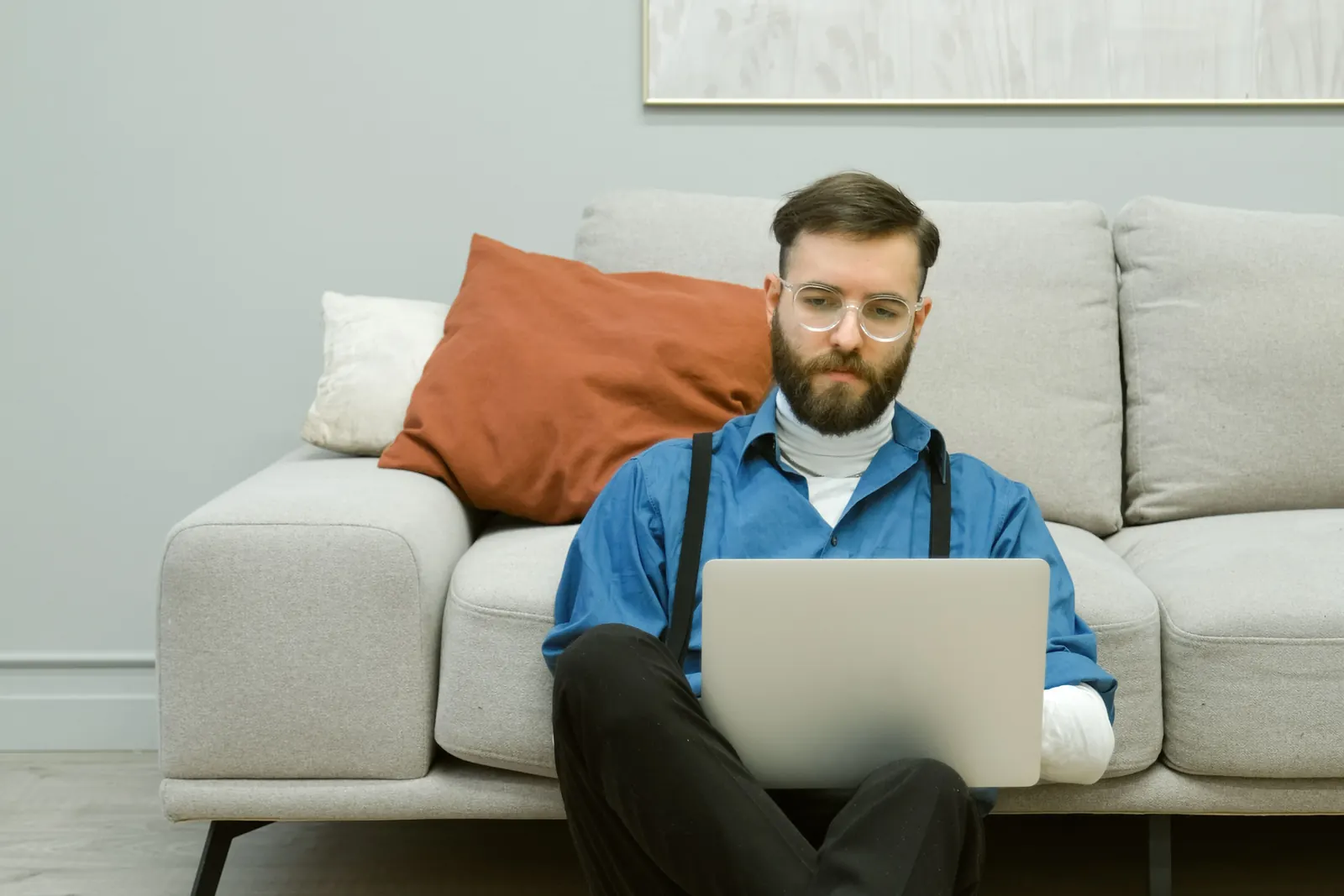 Man sitting on a sofa at home working on a laptop