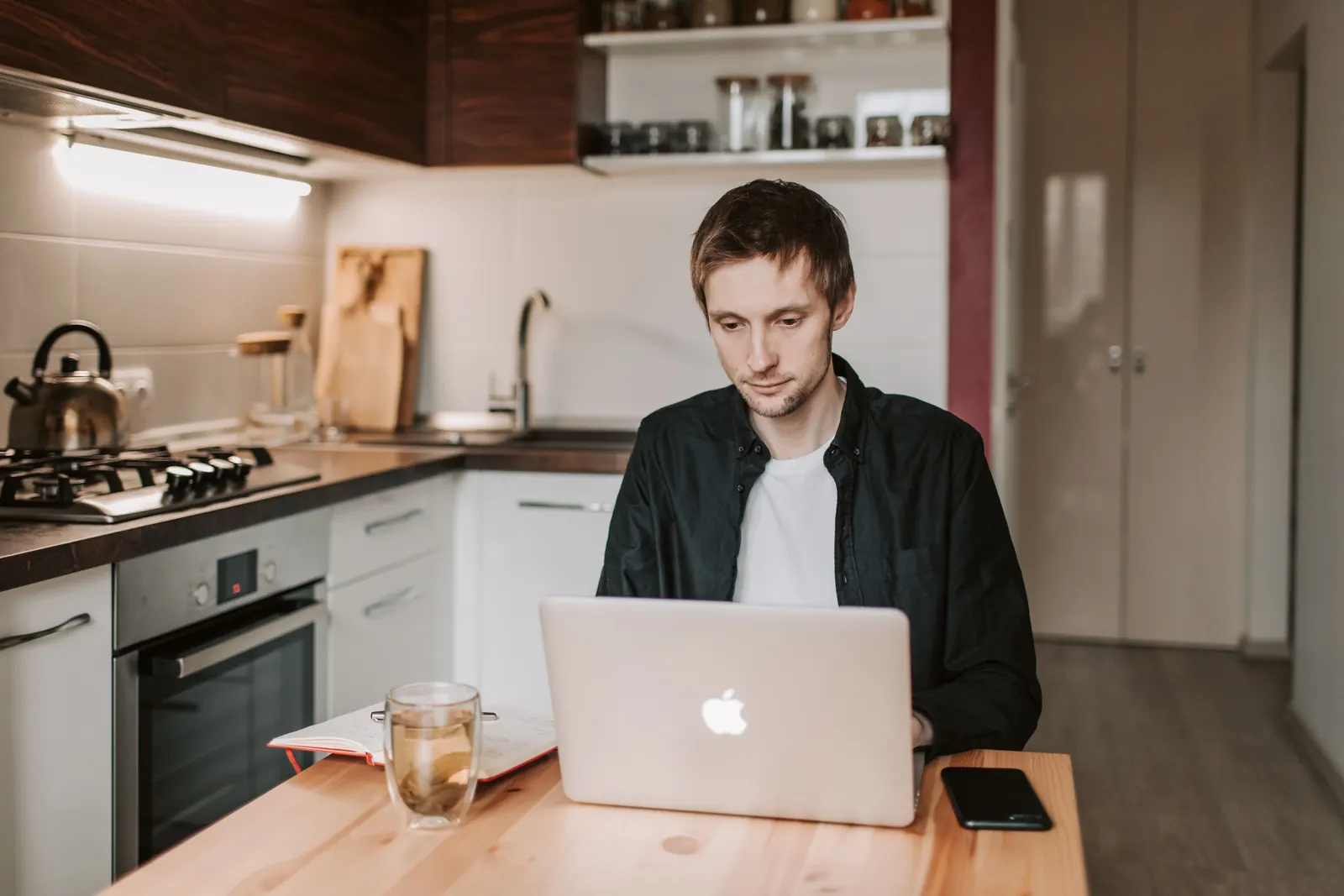 Man reviewing information on a laptop at his kitchen table