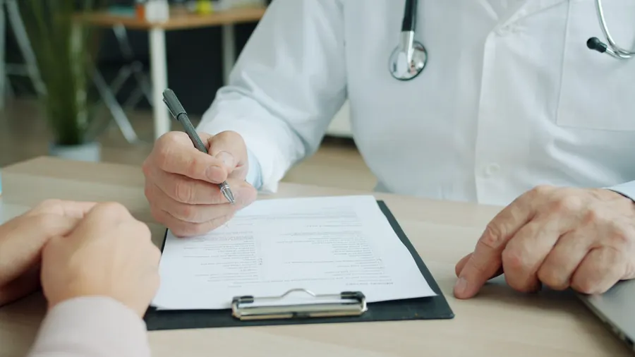 Clinician and patient reviewing paperwork together at a desk