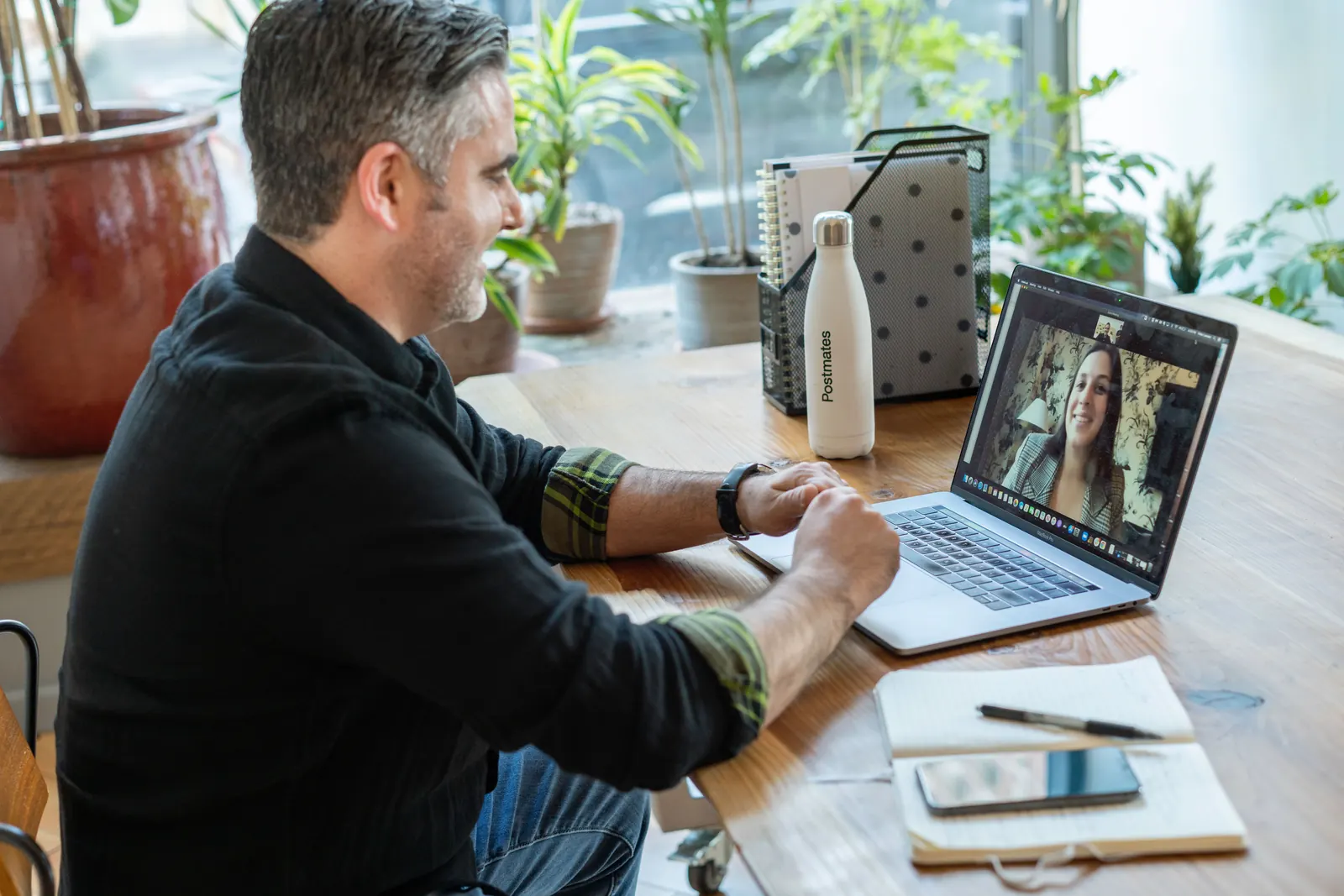 Man at a home desk on a video call with a clinician on his laptop