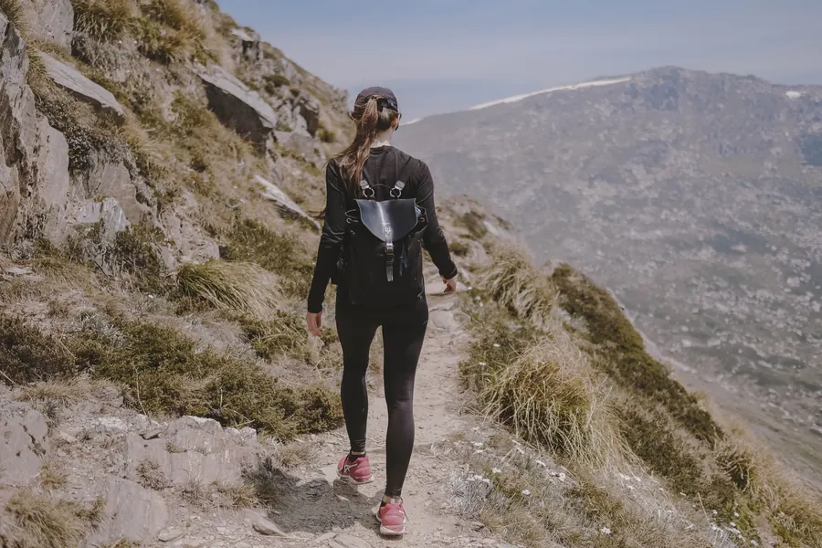 Woman hiking up a rocky mountain trail
